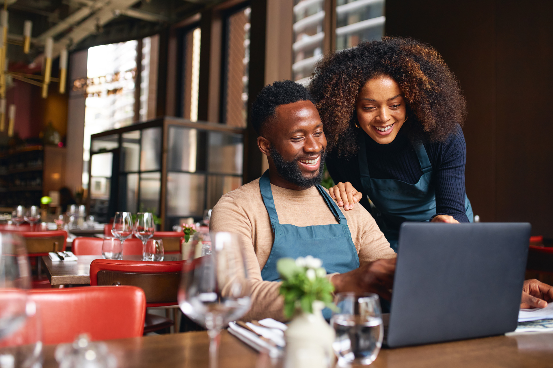 Small business owners working on a laptop in a restaurant