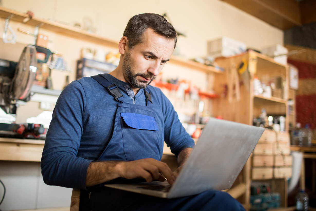 Small business owner working on a laptop in a workshop